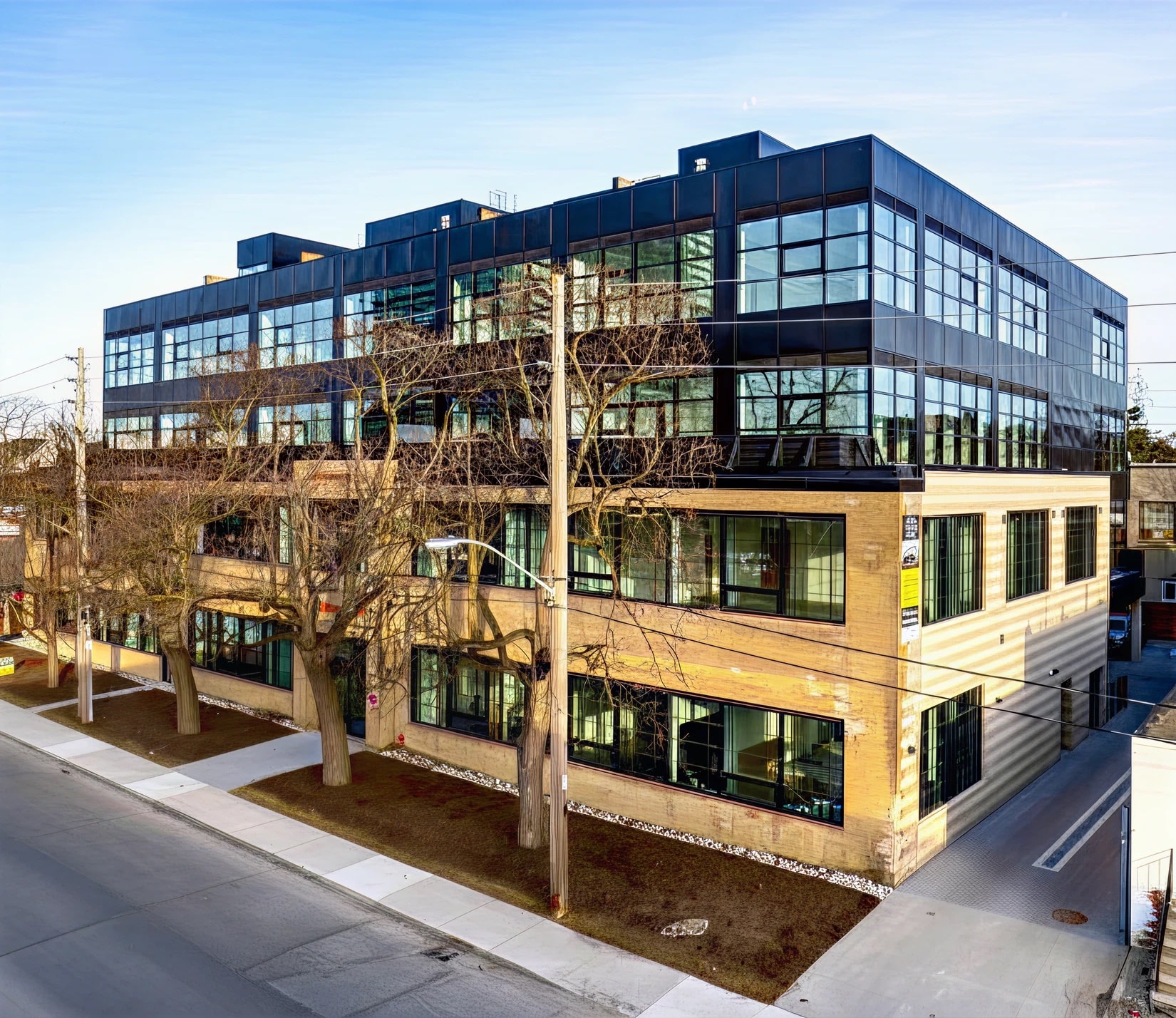 The 300 Geary Avenue exterior — a restored industrial loft building with large operable windows in Toronto's Dufferin & Dupont neighborhood